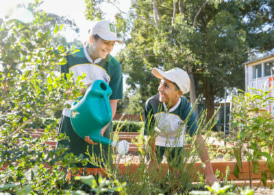 Children watering garden in outdoor environmental learning setting