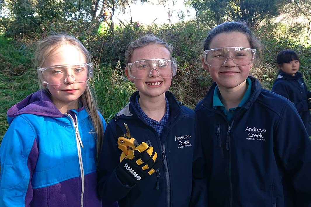 three school students standing outdoors