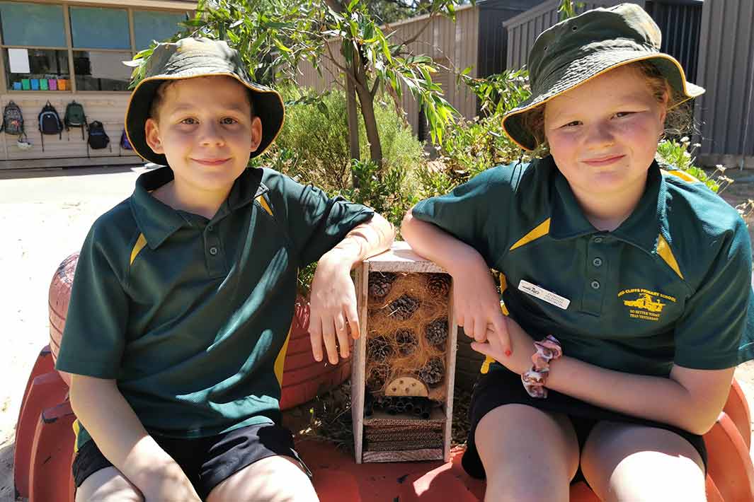 Two Red Cliffs Primary students show off their completed insect hotels