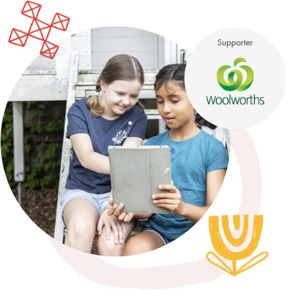 Image Description: Two children, sitting outside interacting with tablet device.