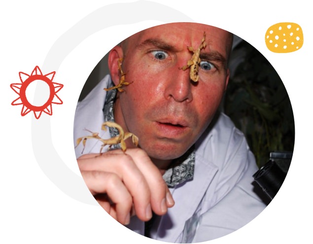 Image Description: Close up of teachers face with stick insects crawling on him. 