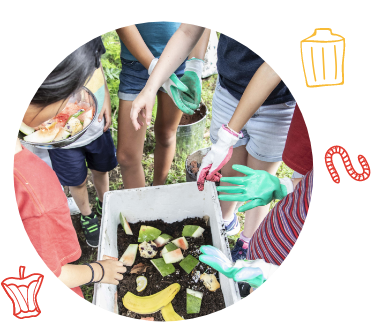 Image Description: Group of school children stand around a compost box container with food scraps inside.