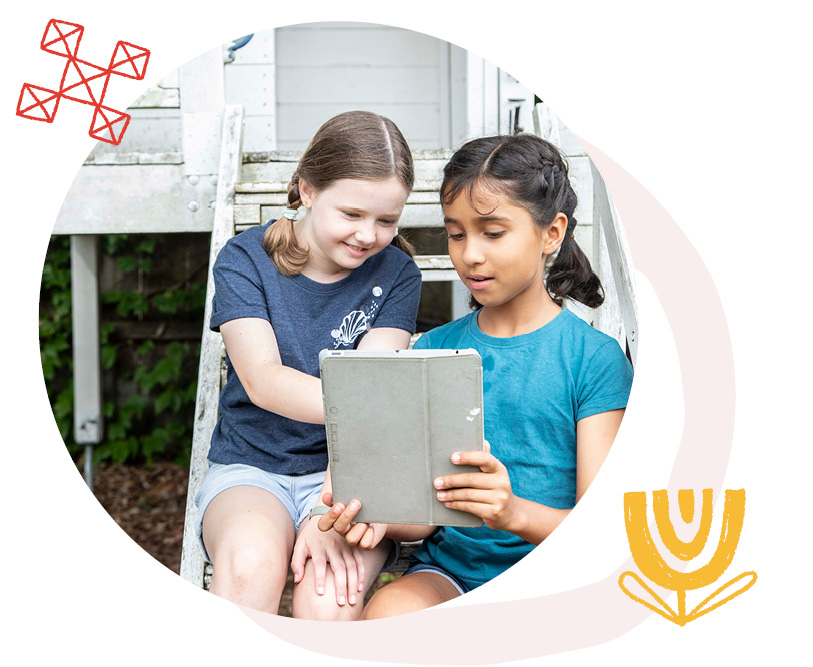 Image Description: Two children interacting with tablet, sitting on stairs outdoors.