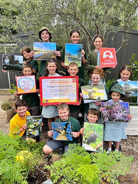 School kids standing in their garden with What's In Your Backyard certificates